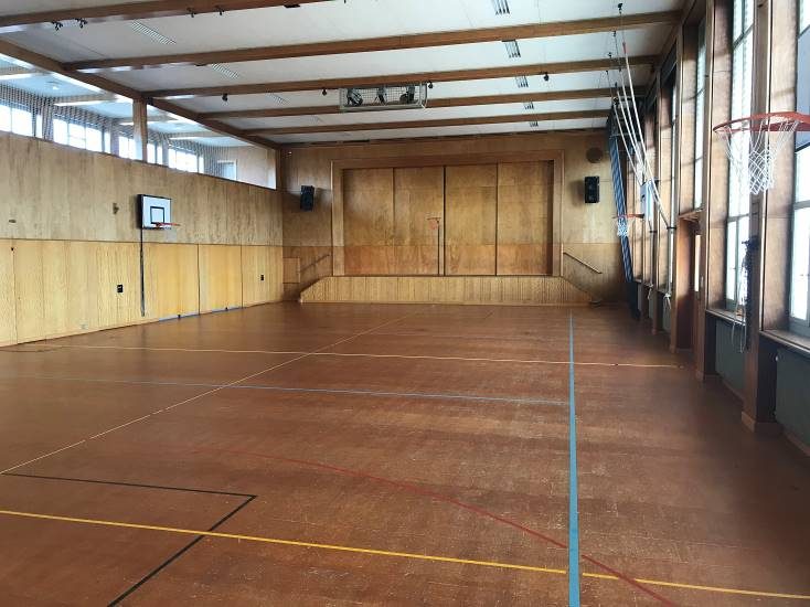 Innenraum der Mehrzweckhalle Oberhofen mit Holztäfer